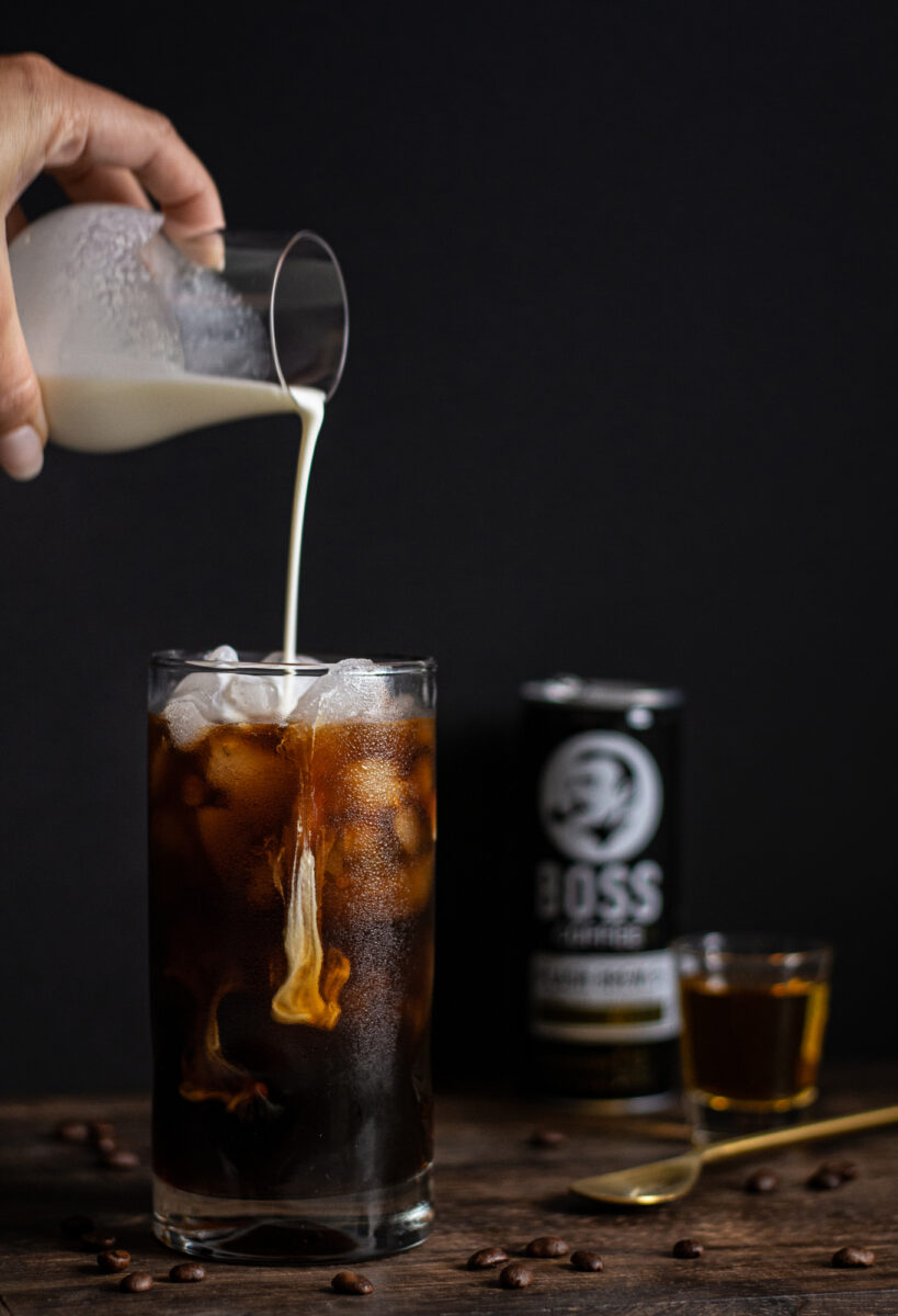 Cream being poured into a glass of BOSS Coffee and Bourbon, making the perfect cocktail.