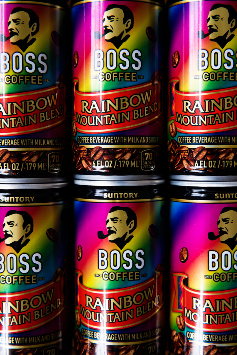 A closeup of a stack of BOSS Coffee Rainbow Mountain Blend cans