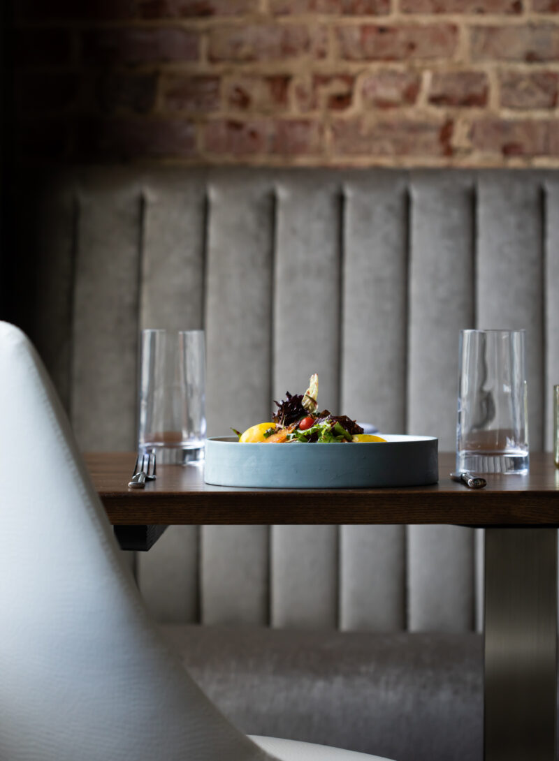 Erbario Tuscano diffusers set on a dark background and styled on gold, mirrored trays.