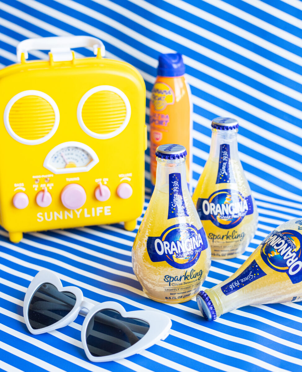 Orangina - Summer Vibes Heart Sunglasses and Radio with Blue Striped Backdrop
