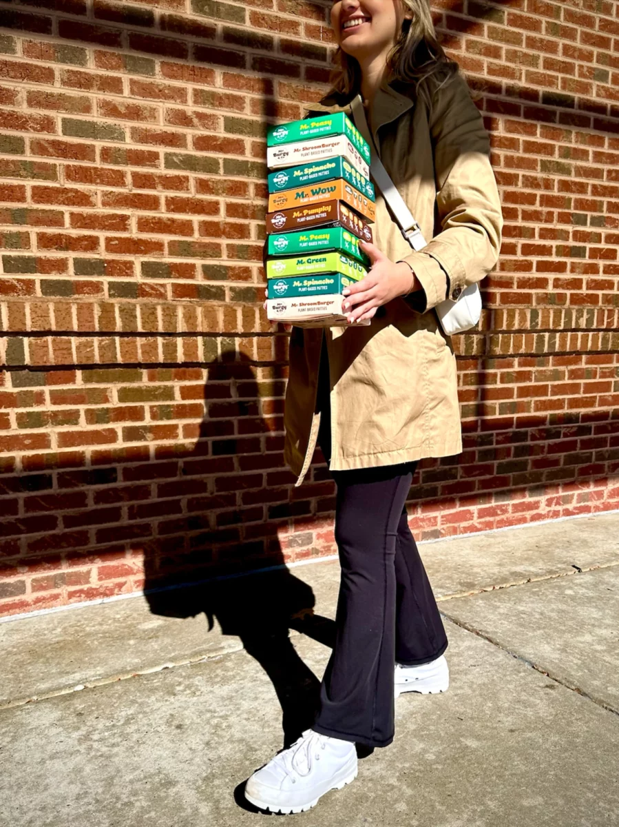 A young woman holding a stack of Mr Burgy and Co boxes
